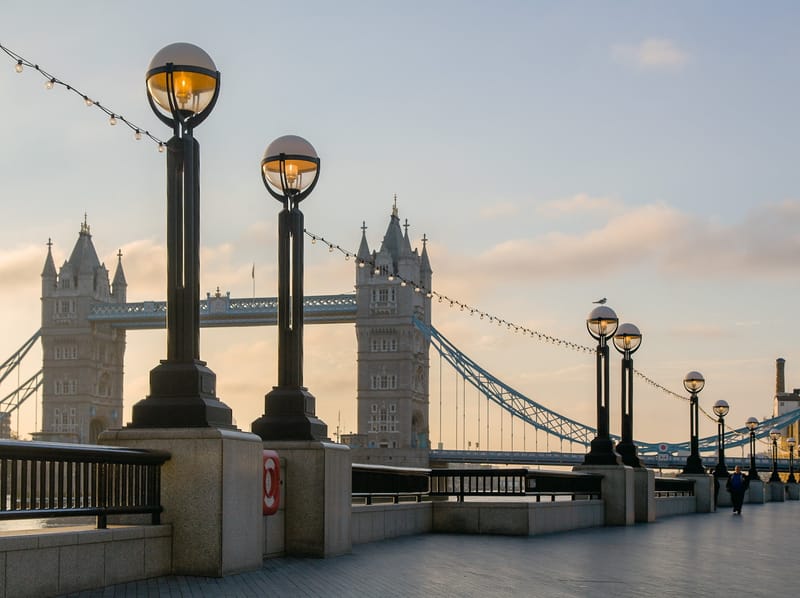 Globe lamps along the riverside at sunrise, Tower Bridge beyond